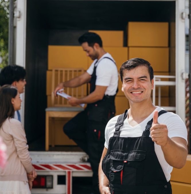 In a portrait a joyful mover unloads boxes from a truck into a new home. These movers display teamwork ensuring efficient relocation and spreading happiness. Moving day concept